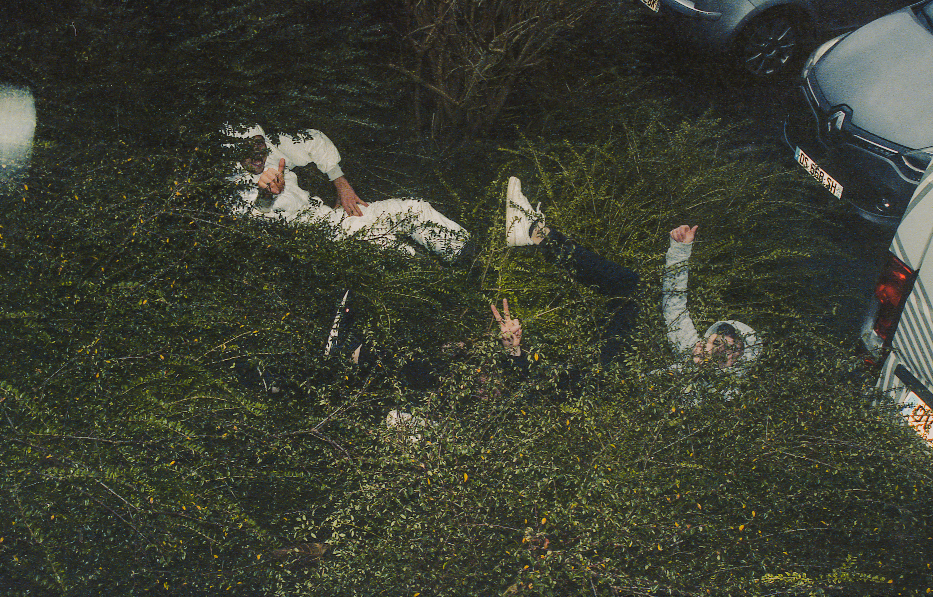 Mushary, France, hobbies – Photograph of three men lying in a bush.