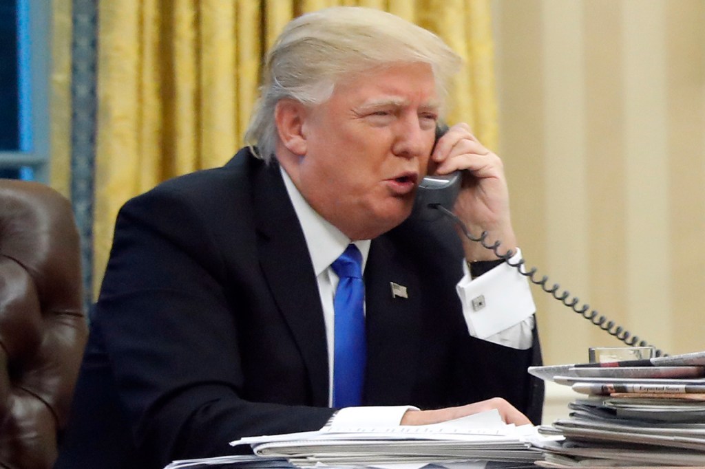 President Donald Trump speaks on the phone with Australian Prime Minister Malcolm Turnbull in the Oval Office of the White House in Washington, Jan. 28, 2017. (AP Photo/Alex Brandon)