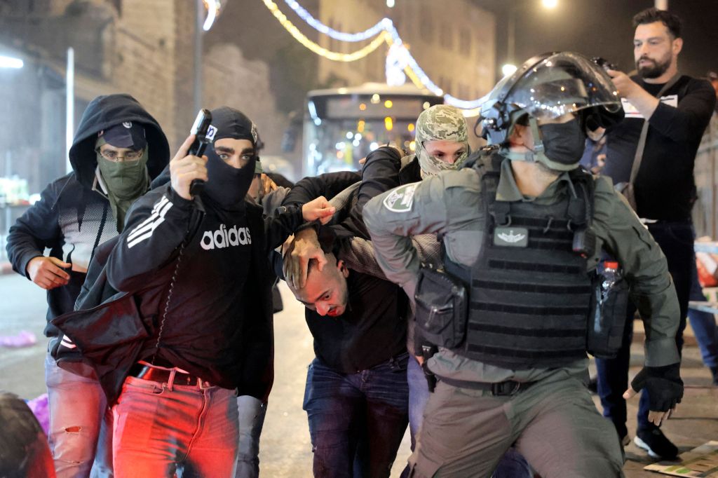 Pasukan Keamanan Israel menangkap lelaki Palestina di luar Gerbang Damaskus, Kota Tua Israel pada 3 April 2022. Foto: Hazem Bader / AFP