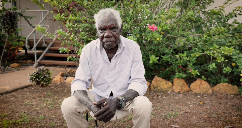 Person sitting in garden.