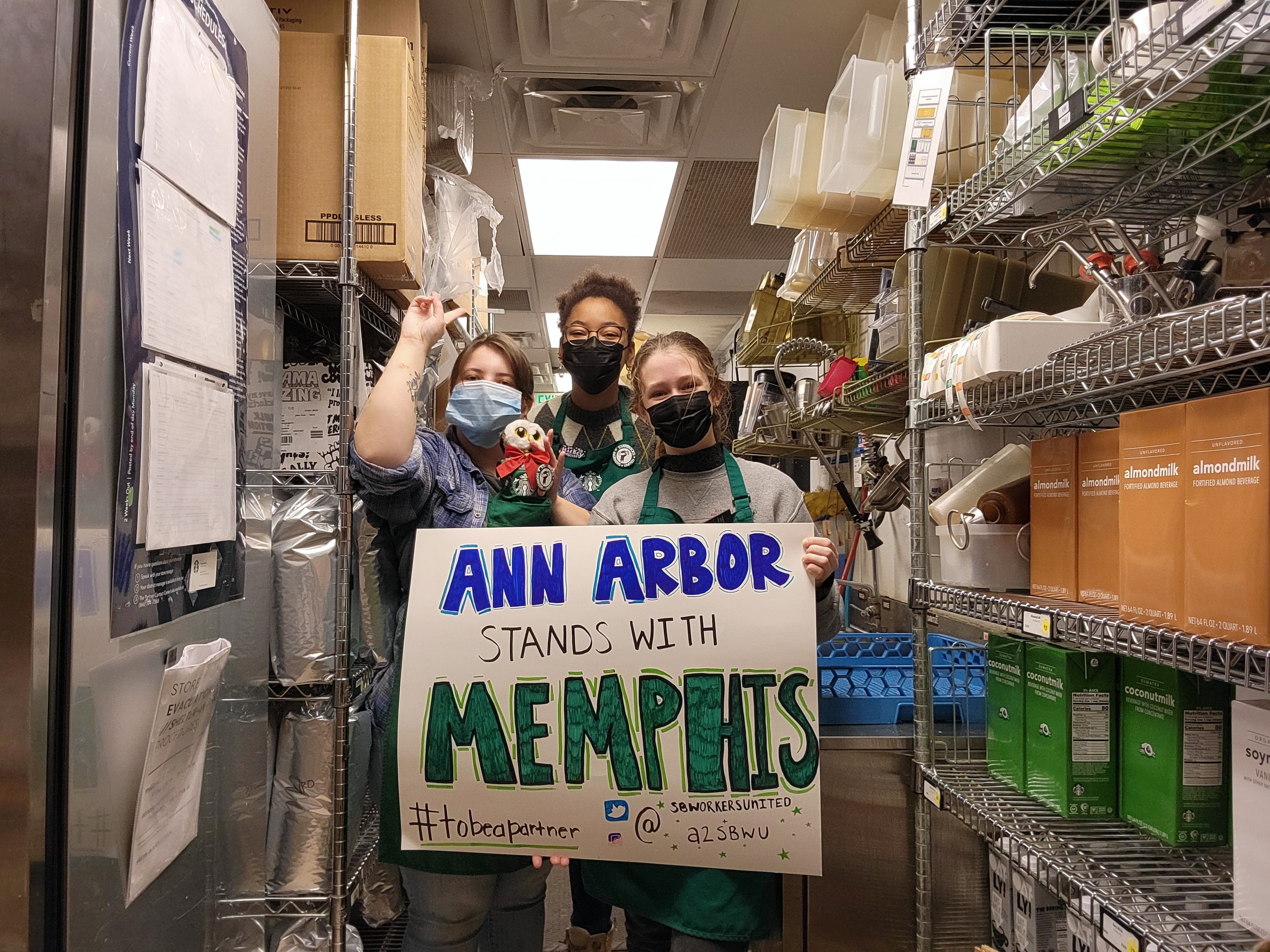 Whitbeck and two coworkers holding up a sign expressing solidarity with seven workers fired in Memphis. (Courtesy of Hannah Whitbeck)