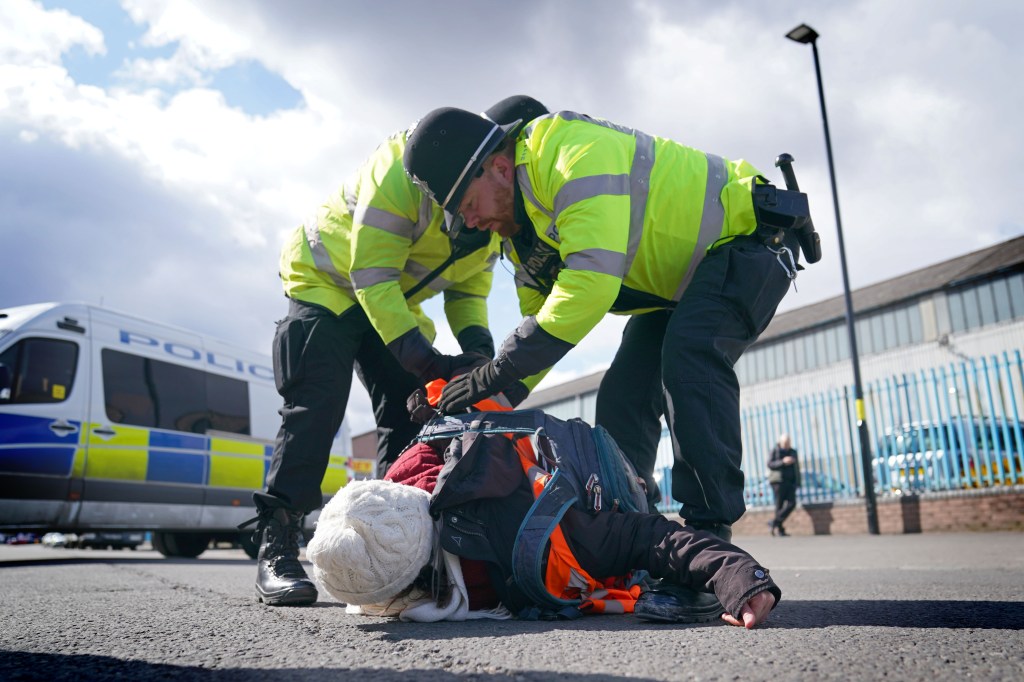 Police remove a Just Stop Oil activist taking part in a blockade of the ESSO Birmingham Fuel Terminal