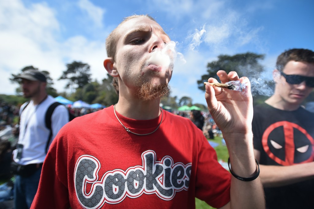 Kenny Boynton smokes a joint on Hippie Hill in San Francisco, California on Friday, April 20, 2018. (AP Photo/Josh Edelson)