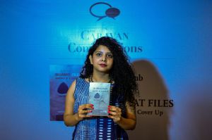 In this photograph taken on May 27 Indian journalist and author, Rana Ayyub poses with her self published book 'Gujarat Files' during the launch event in New Delhi. / AFP / CHANDAN