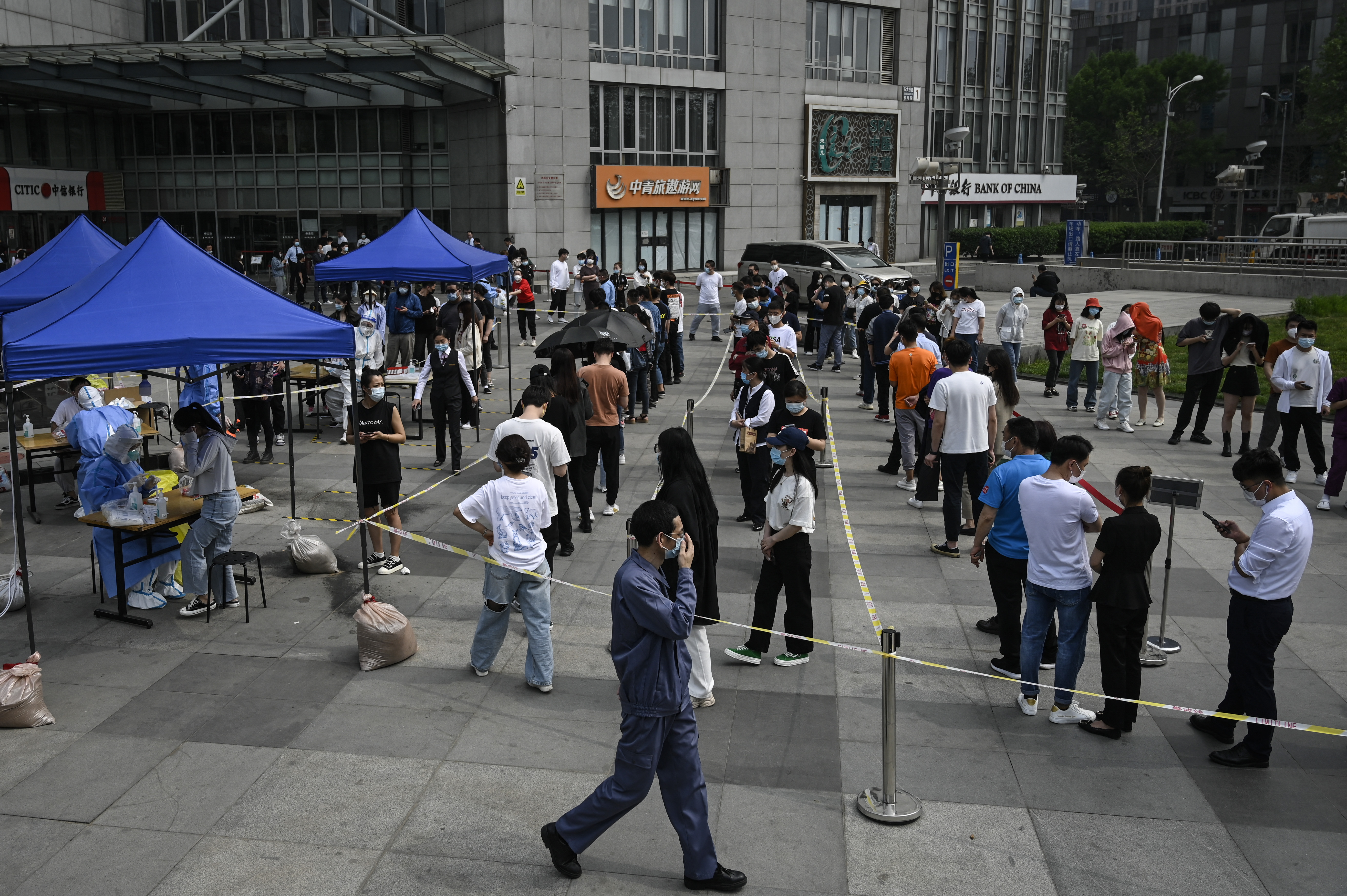 People line up to be tested for the coronavirus at a makeshift testing site outside office buildings in Beijing on Monday. Photo: Jade GAO / AFP