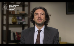 Photo shows David Sabatini in a suit and tie in front of a shelf.