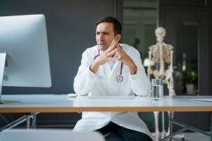 A doctor looking at a computer screen with surprise. Getty Images.