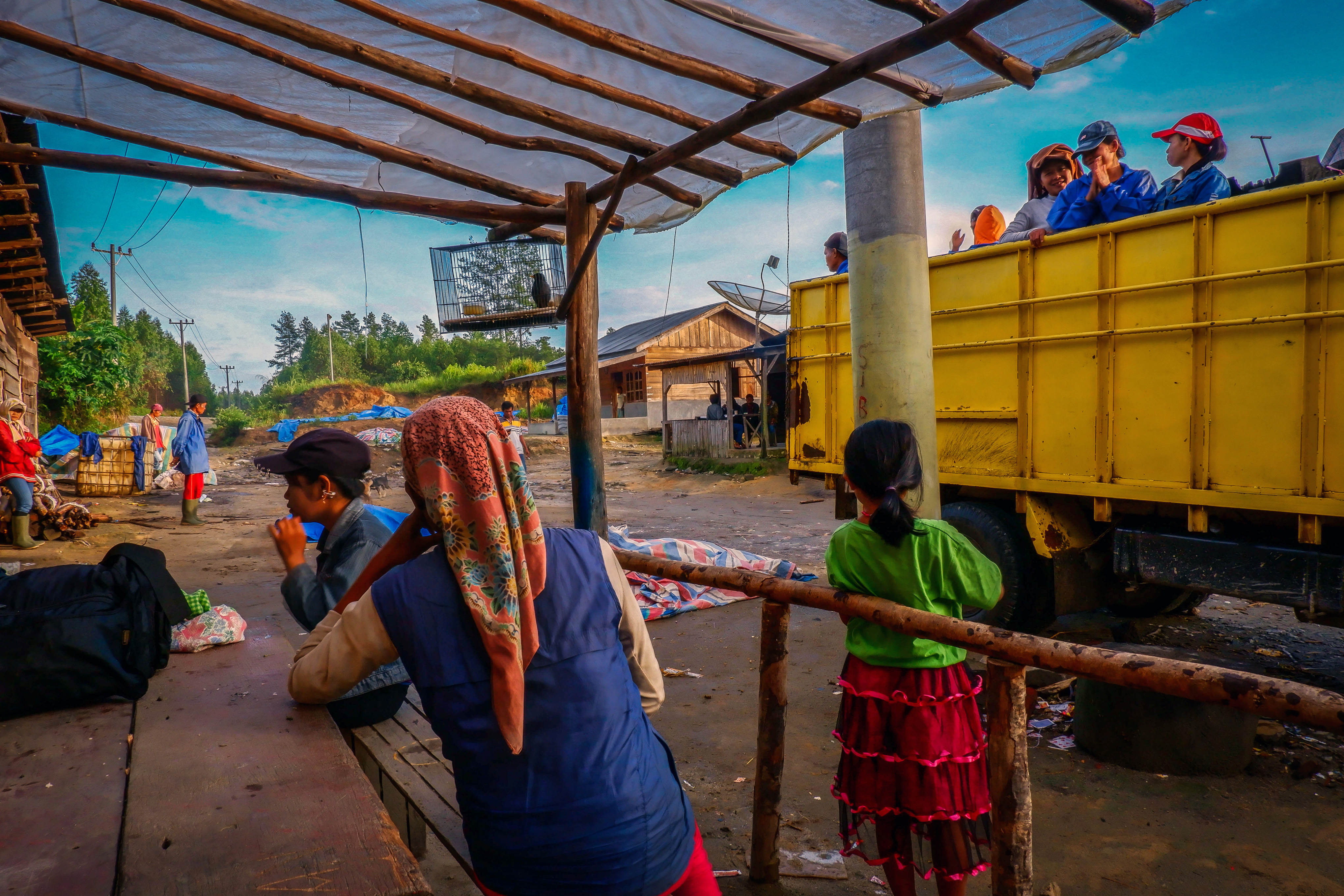 Workers board trucks each morning to be taken to the plantation. On the day VICE World News reporters were there, several underage girls stayed behind at the barracks. Photo: Albert Ivan Damanik