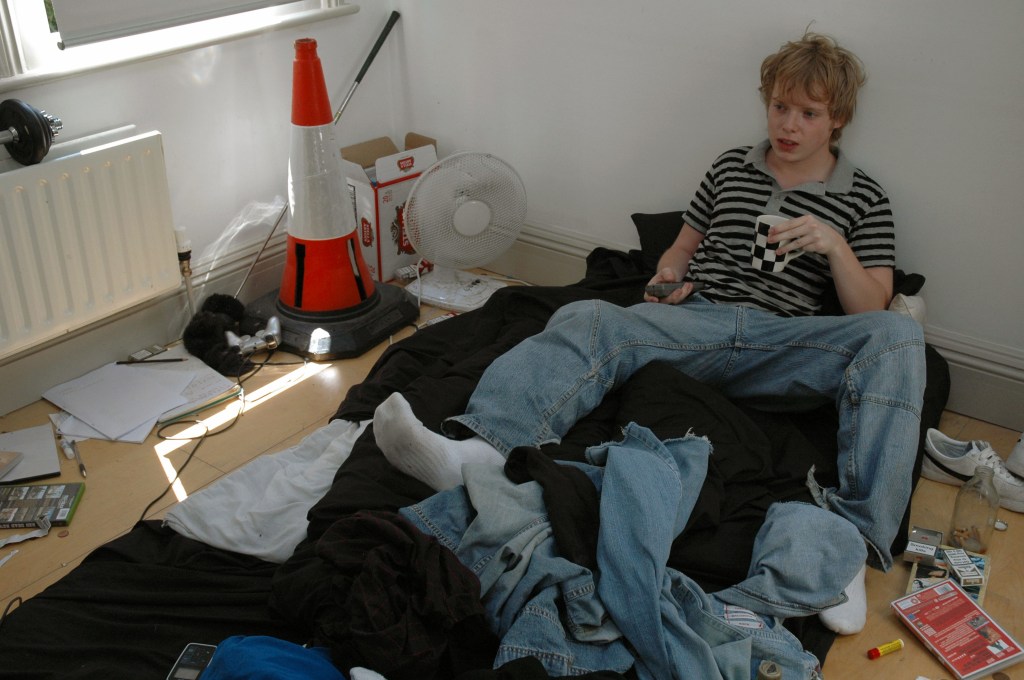 A single man lying on a bed with unwashed sheets