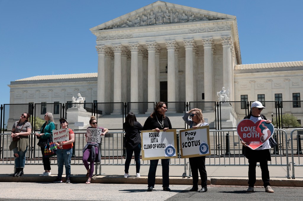 Pro-abortion rights and anti-abortion protesters stand in front of the U.S. Supreme Court building on May 10, 2022 in Washington, DC.​