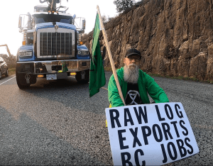 ​Howard Breen holds a sign during an eco-protest.