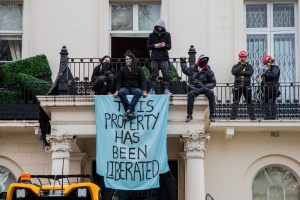 Anti war demonstrators on the balcony of London Mansion linked to a Russian oligarch.  Photo: Thabo Jaiyesimi/SOPA Images/LightRocket via Getty Images