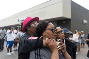 People watch the crime scene of an active shooter across the street from the Tops Friendly Market on Jefferson Avenue and Riley Street in Buffalo.