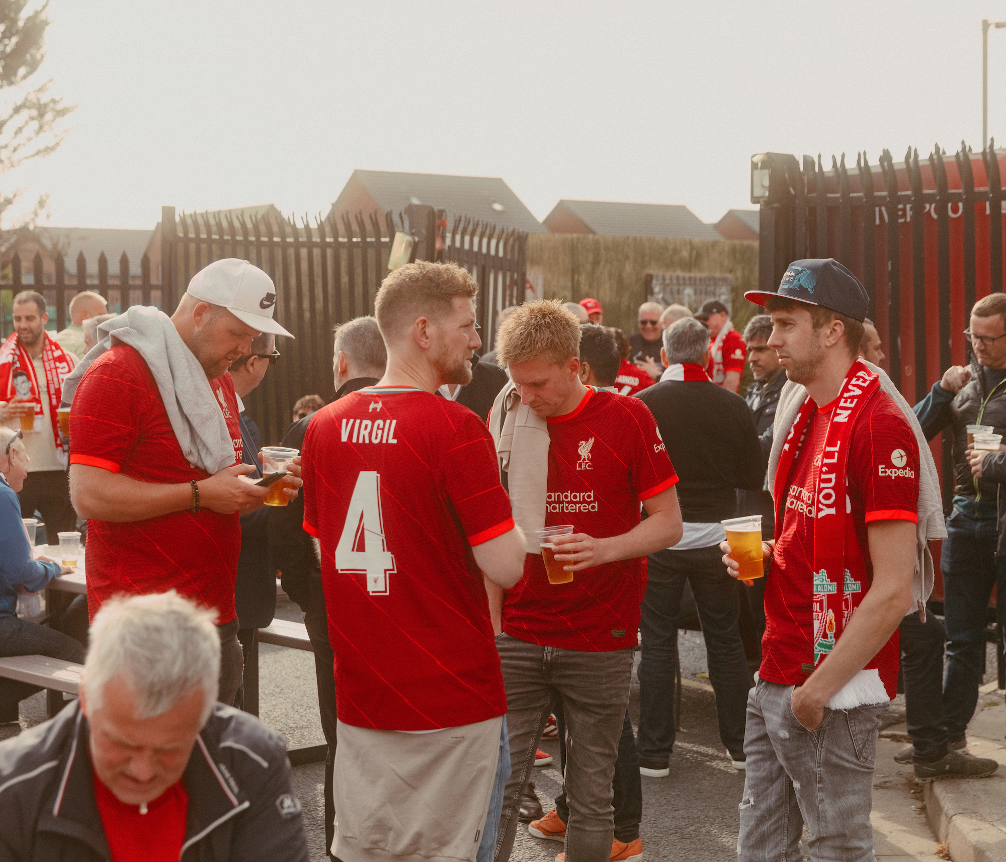 Liverpool fans holding pints in the sun