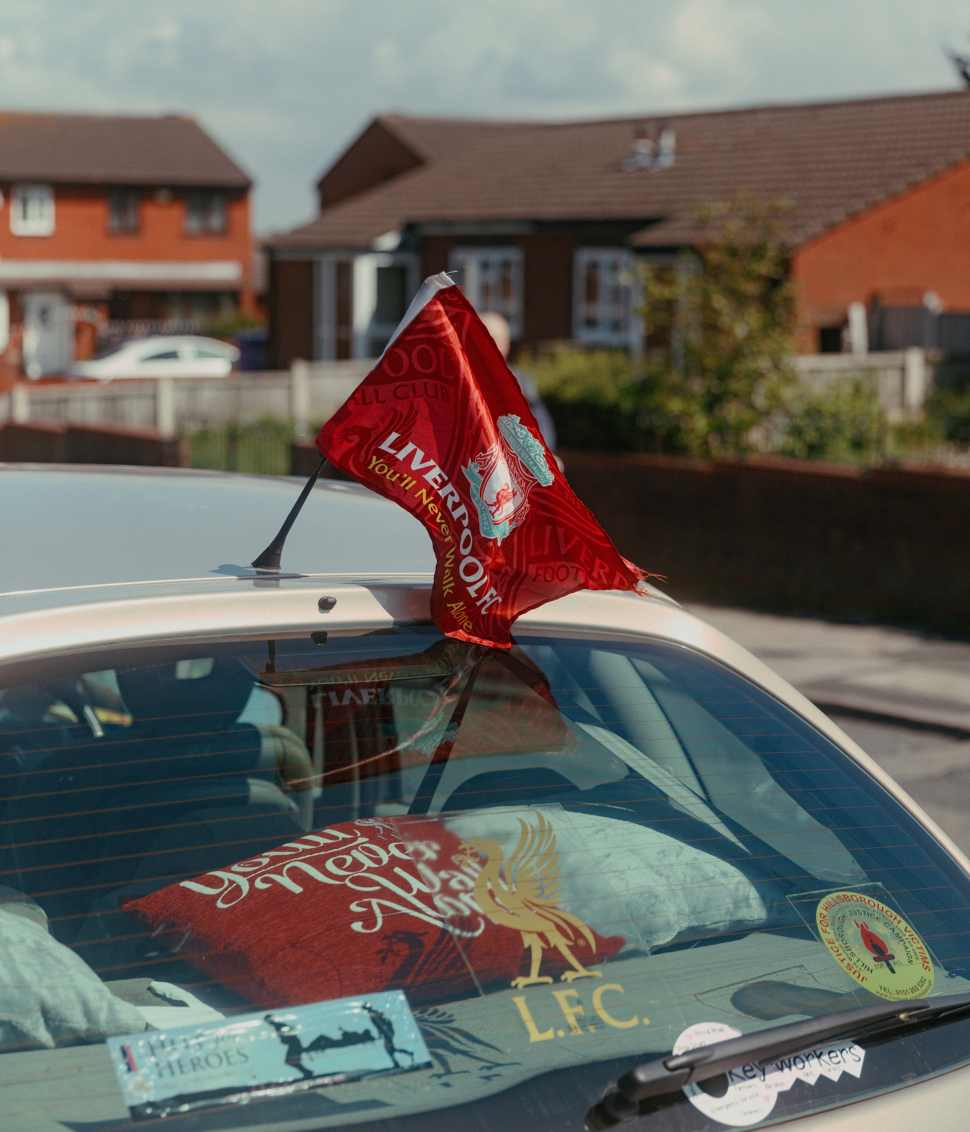 A Liverpool flag flies from the back of a car