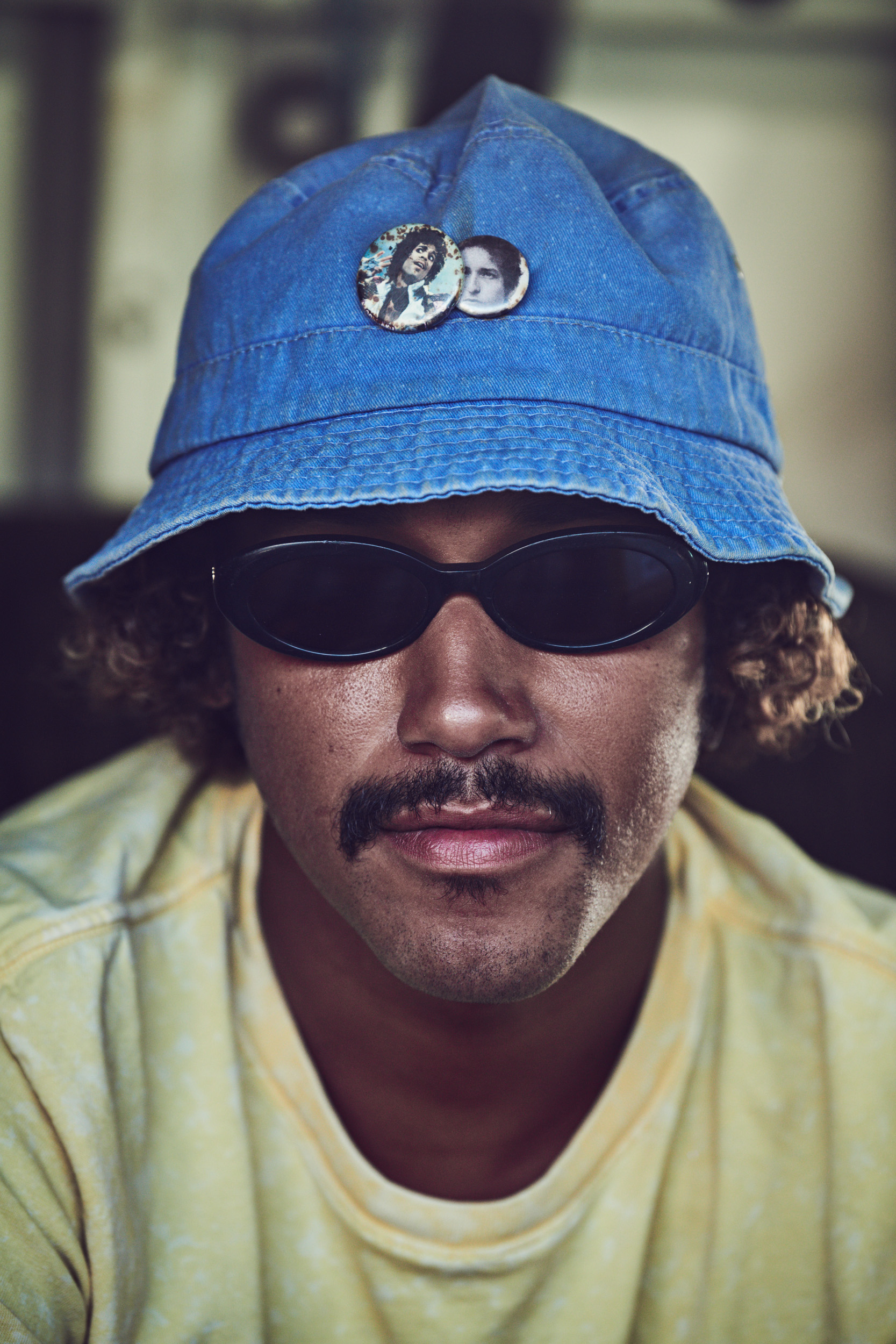 Venice Beach, California: A surfer looks ahead in sunglasses and a bucket hat. Photo by Matthew Brookes, from Into the Wild, published by Damiani​