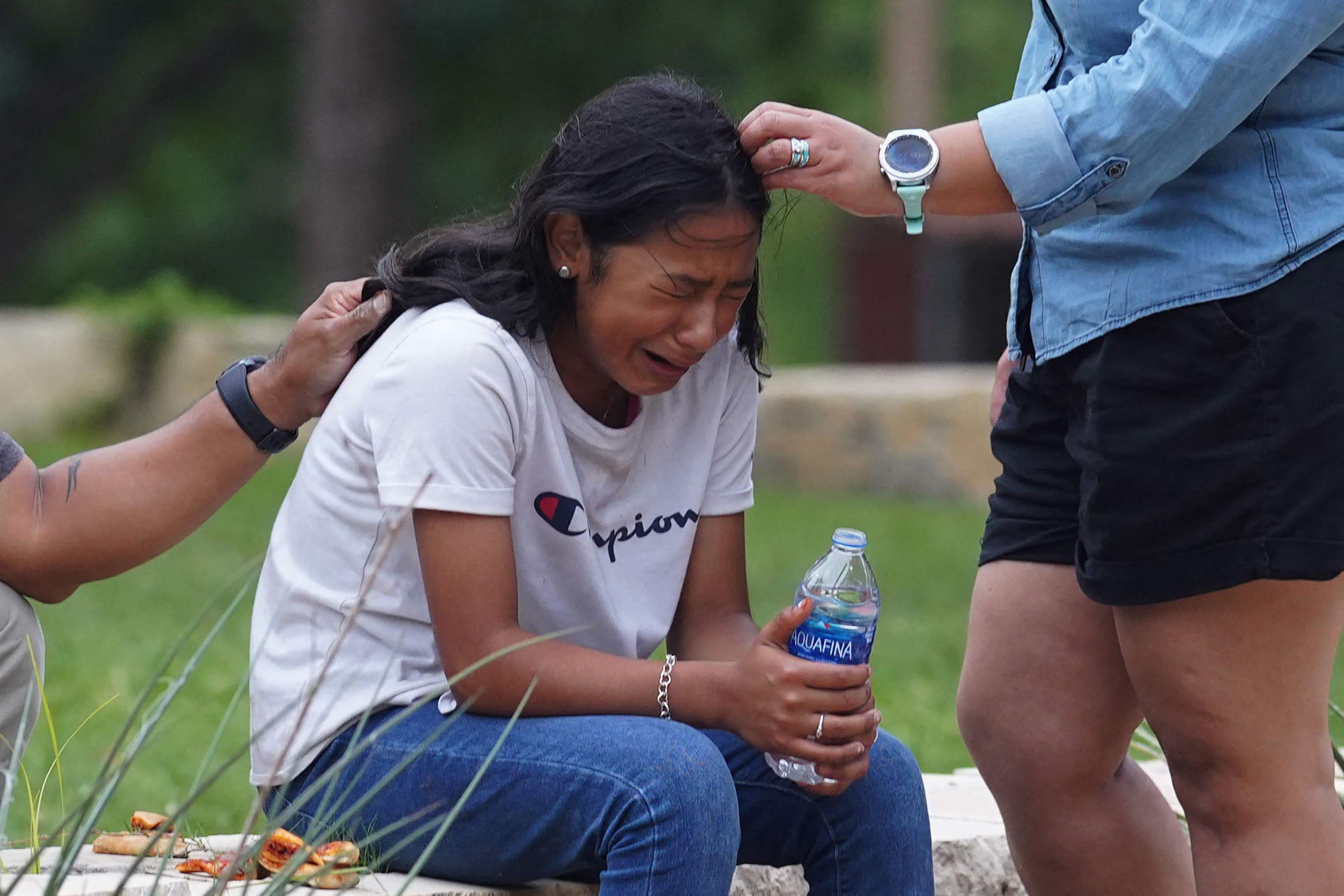 A sobbing girl is comforted by two adults outside the Willie de Leon Civic Center, where families waited anxiously to reunite with their children. Photo: ALLISON DINNER/AFP via Getty Images