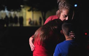 Families hug outside the Willie de Leon Civic Center where grief counseling will be offered in Uvalde, Texas, on May 24, 2022.  (ALLISON DINNER/AFP via Getty Images)