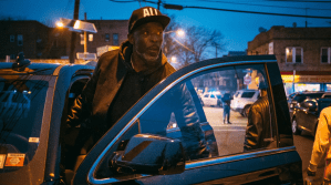 Michael K. Williams in Black Market getting out of a car