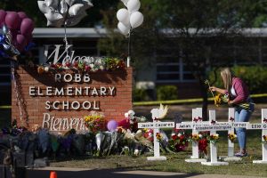 People drop off flowers at a makeshift memorial outside the Robb Elementary School on May 26, 2022 in Uvalde, Texas.