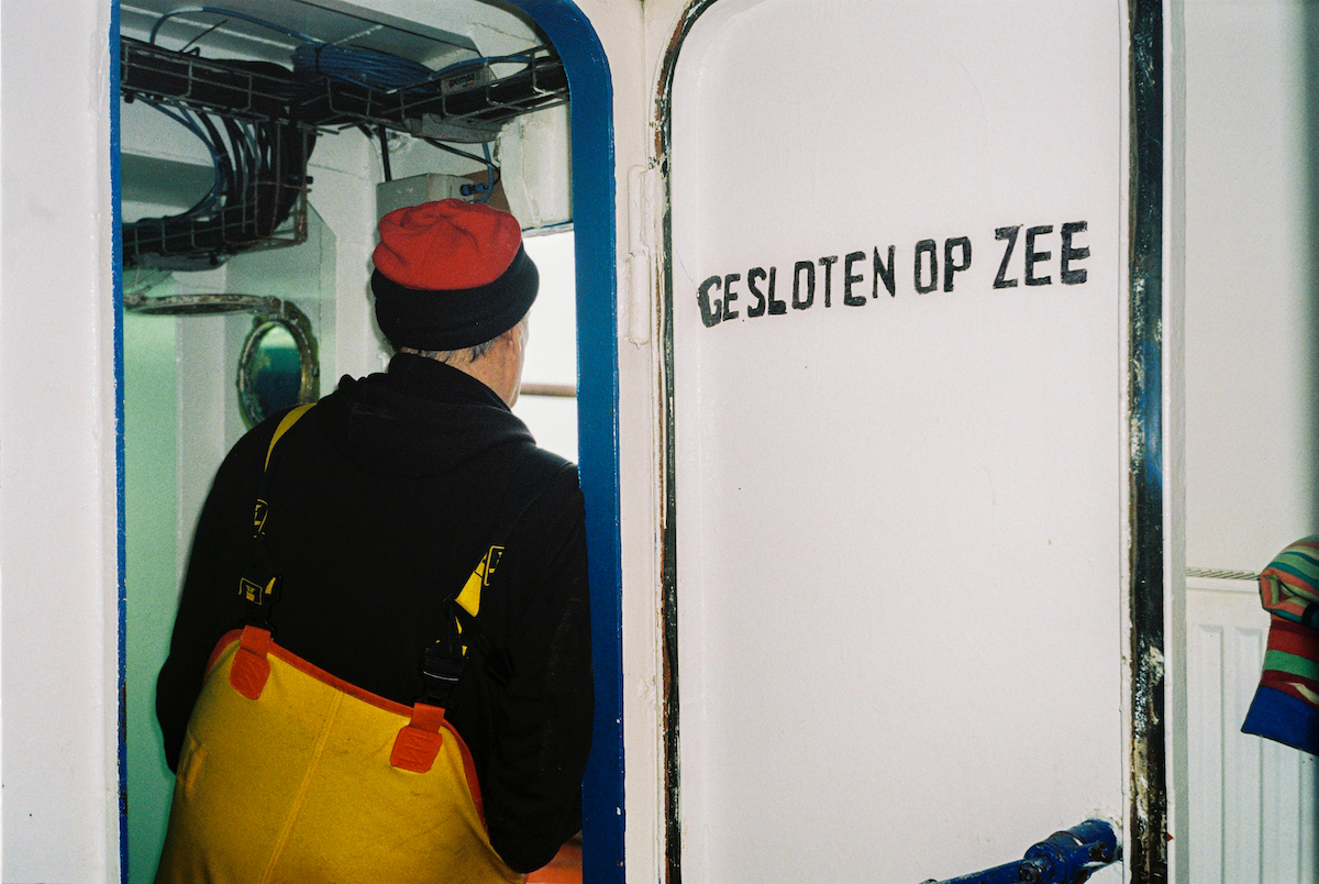 Ostend, fishing, photography - Photograph of the back of a fisherman, peering into sea.