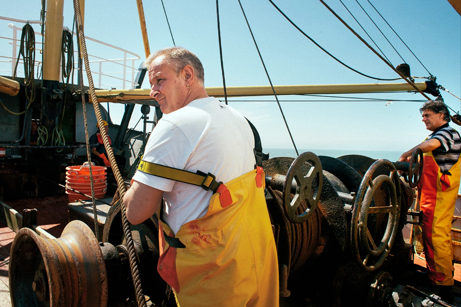 Ostend, fishing, photography - Photograph of two fishermen wearing yellow rubber dungarees on a fishing vessel.