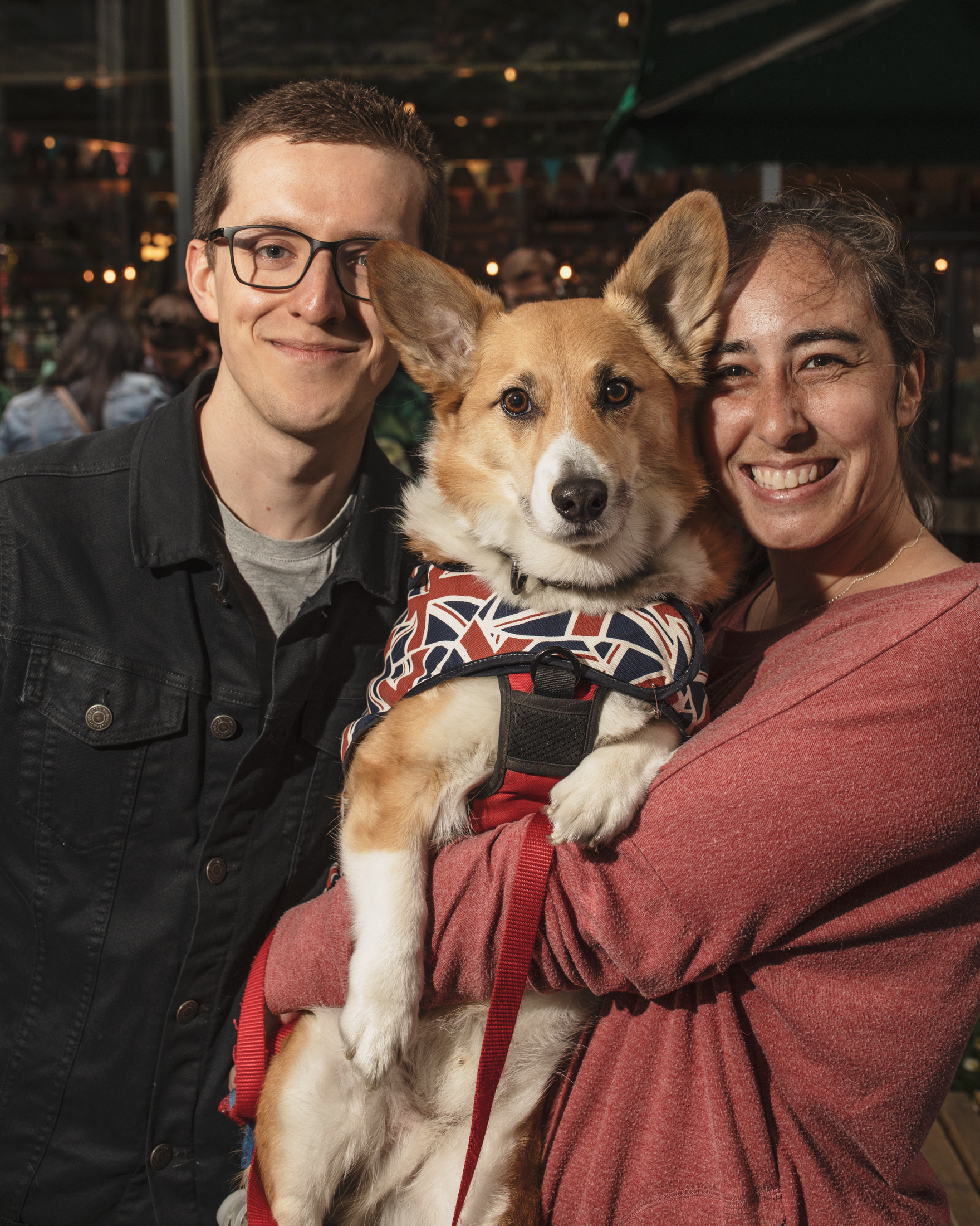 A couple holding up a corgi pet the London corgi cafe for Platinum Jubilee