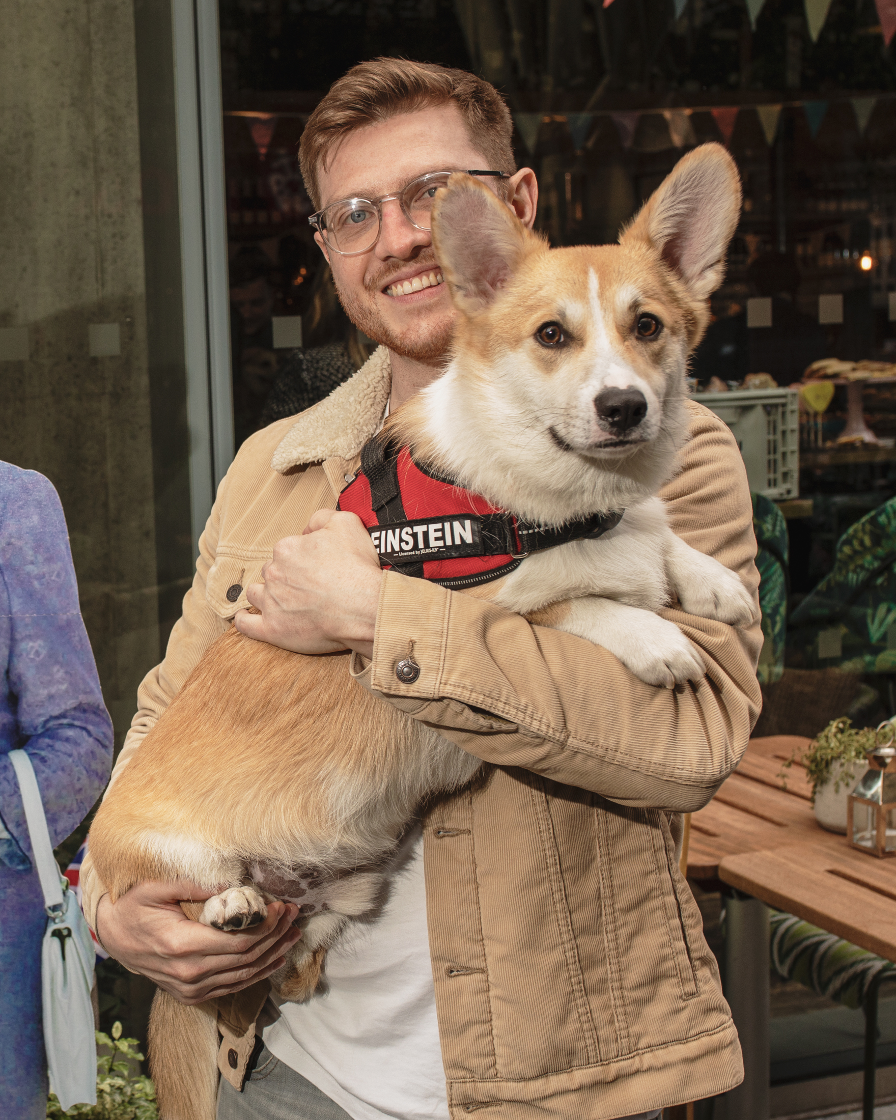 A man holding his corgi at the Platinum Jubilee themed cogi cafe