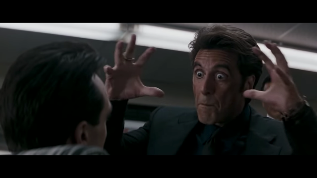 Screenshot from Heat - Al Pacino holds out his hands in front of his face to show how large an ass he's talking about.