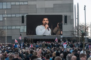 People in crowd looking at photo of avi yemini