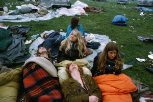 A group of festival goers lie together under blankets and sleeping bags at the first Glastonbury Festival, United Kingdom, September 1970