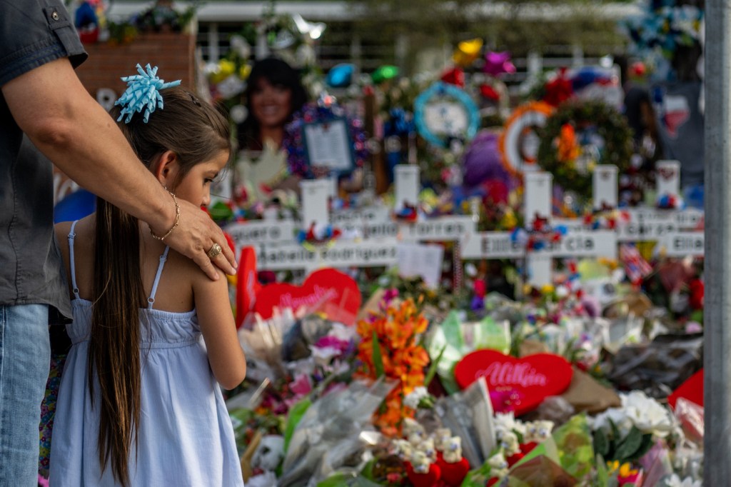 Seth Garza pays his respects with his daughter Lilly at a memorial dedicated to the 19 children and two adults killed on May 24th during the mass shooting at Robb Elementary School on May 31, 2022 in Uvalde, Texas. (Brandon Bell/Getty Images)