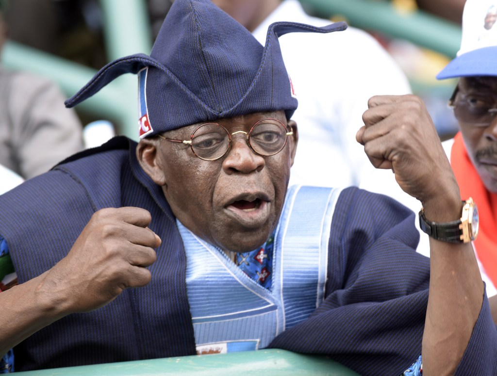 Bola Tinubu, one of the leaders of Nigeria's leading opposition All Progressive Congress, tries to calm the crowd after violence broke out during a campaign rally at the Taslim Balogun Stadium in Lagos