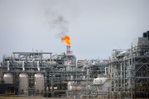 A flame blazes on top of flare stacks at a gas plant in Queensland, Australia