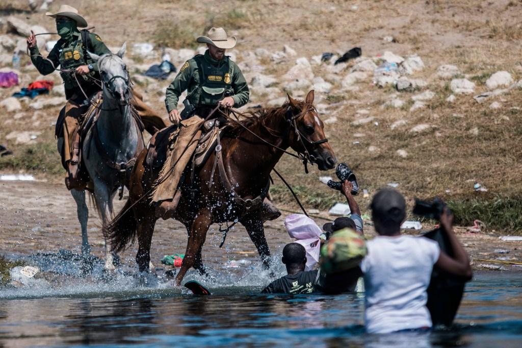 Mounted U.S. Border Patrol agents attempt to contain migrants as they cross the Rio Grande into Del Rio, Texas, Sept. 19, 2021. (AP Photo/Felix Marquez, File)