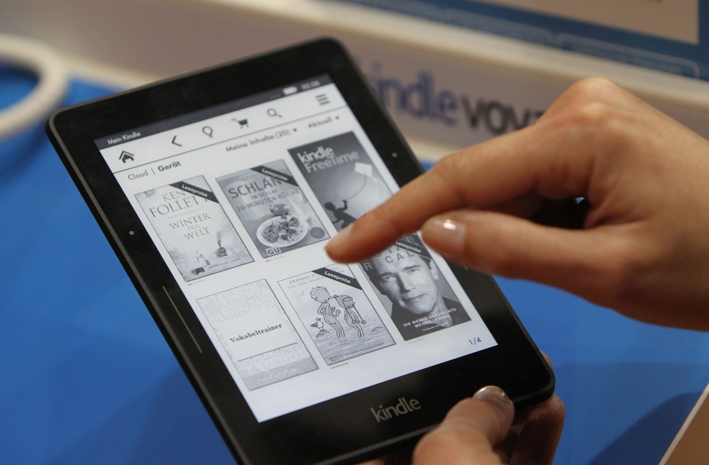 A person's hands holding a Kindle ebook reader