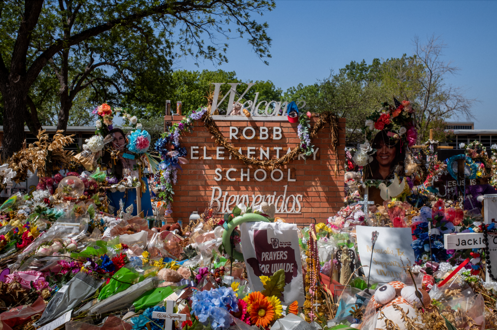 The Robb Elementary School sign is seen covered in flowers and gifts on June 17, 2022 in Uvalde, Texas.