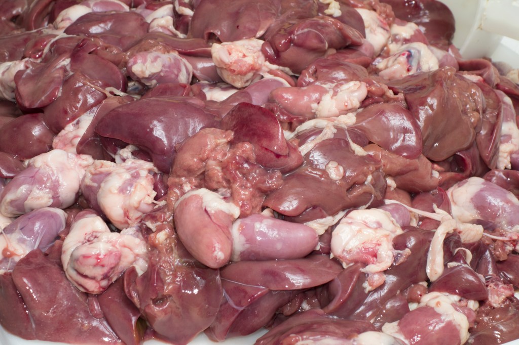 Photo shows a pile of hearts and other organ meats.