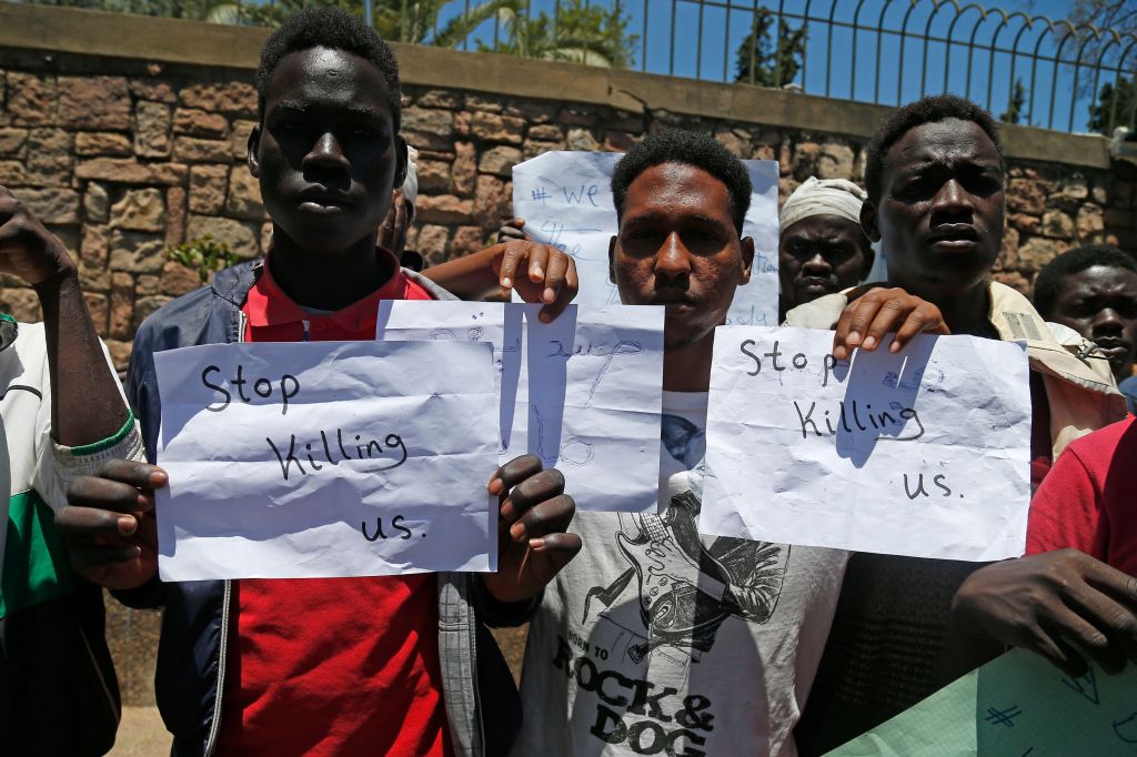 Migrants hold placards during an anti-racism demonstration in the Moroccan capital Rabat