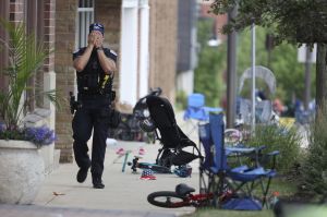 A Lake County, Illinois, police officer walks down Central Avenue in Highland Park on July 4, 2022, after a shooter fired on the northern suburb's Fourth of July parade. (Brian Cassella/Chicago Tribune/Tribune News Service via Getty Images)