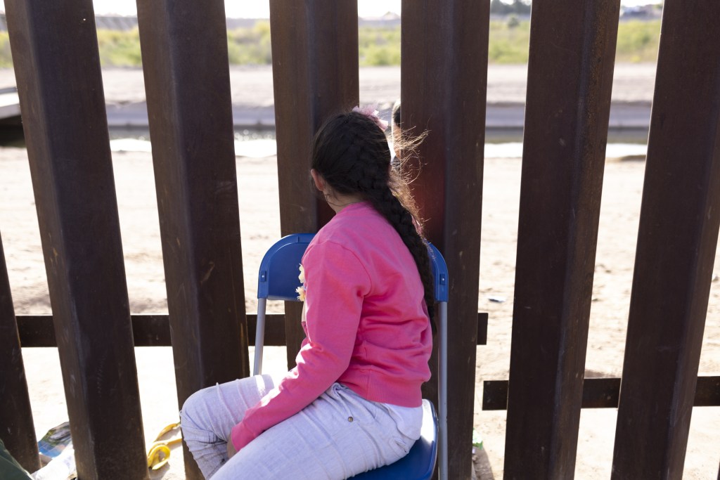 A migrant child seeking asylum waits to be processed by U.S. Border Patrol agents after crossing the Mexico and U.S. border in Yuma, Arizona, U.S. on Tuesday, May 3, 2022.