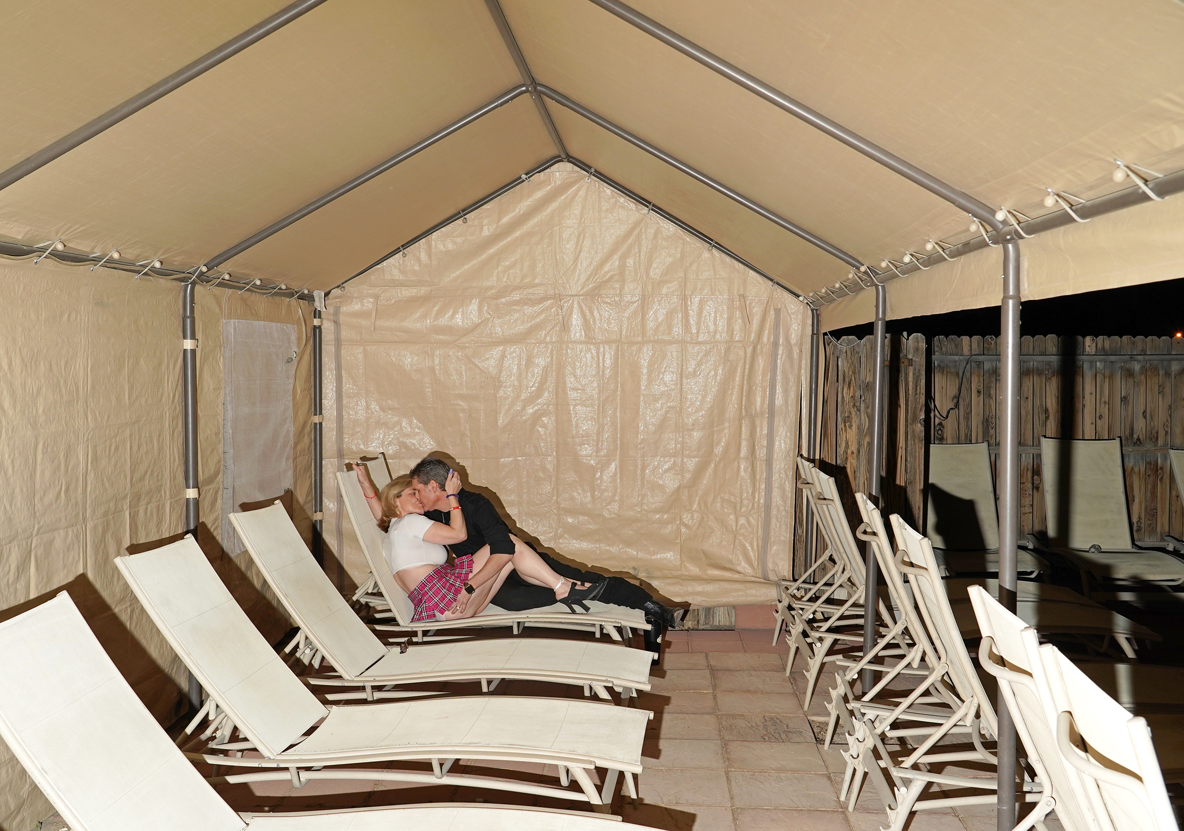 A man and a woman kiss in a cabana at Whispers