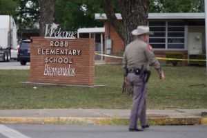 Police officer walks outside school in Uvalde.