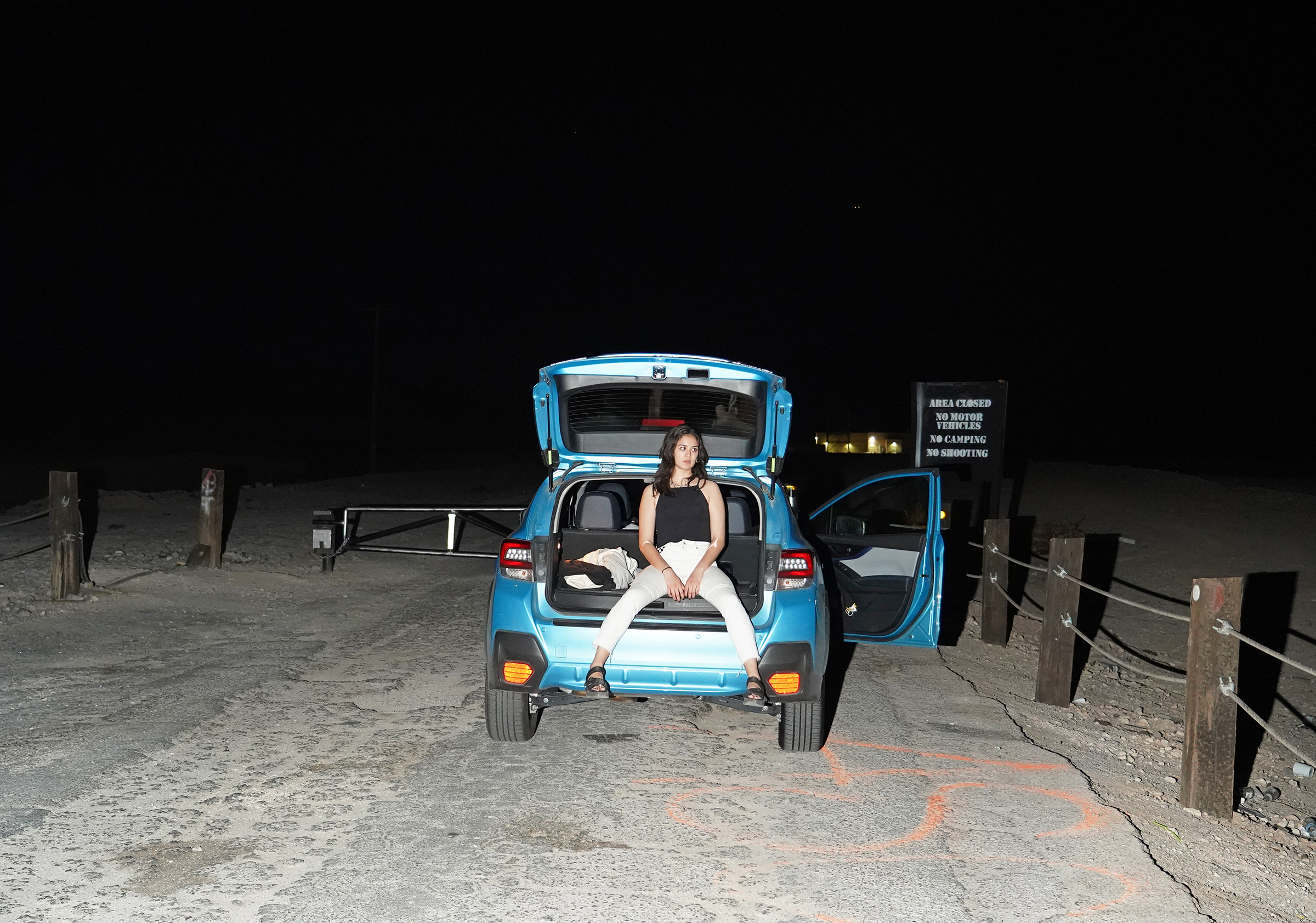 Writer Katie Way sitting on blue car