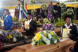 People attend the mass funeral for 21 young victims of last week's tavern tragedy in East London.