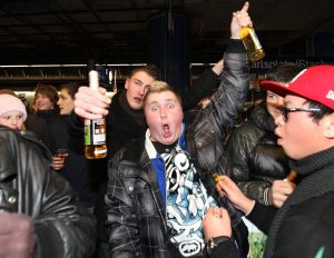 Junge Menschen feiern auf einem Bahnsteig in München