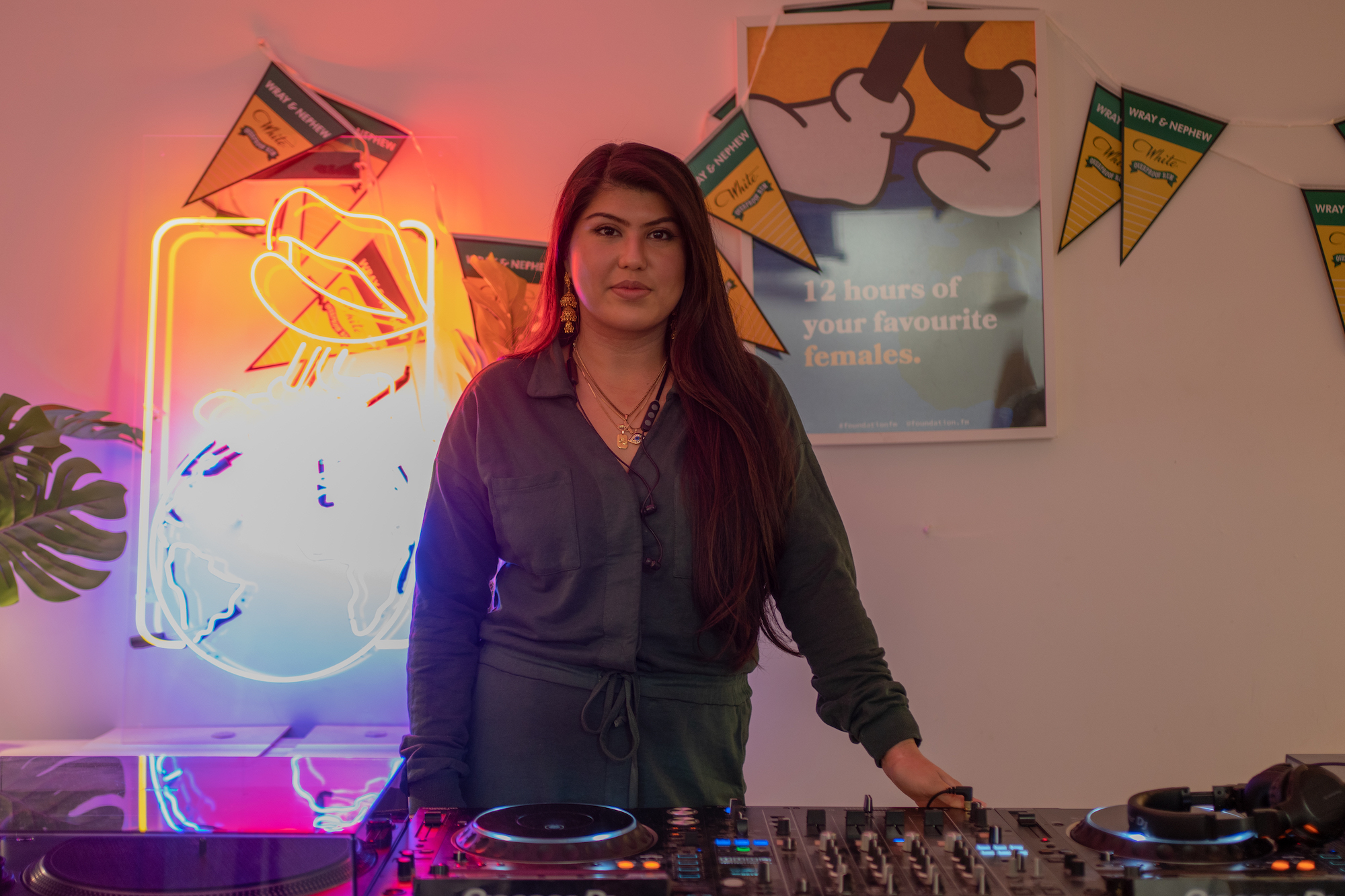 South Asian female DJ standing behind decks