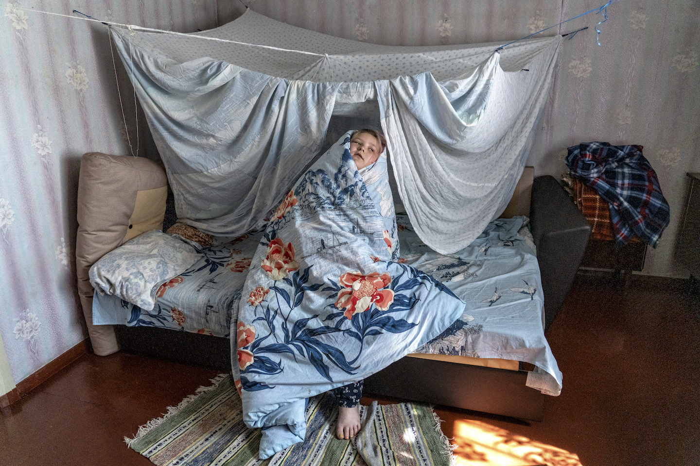 A child wrapped up in bedsheets.