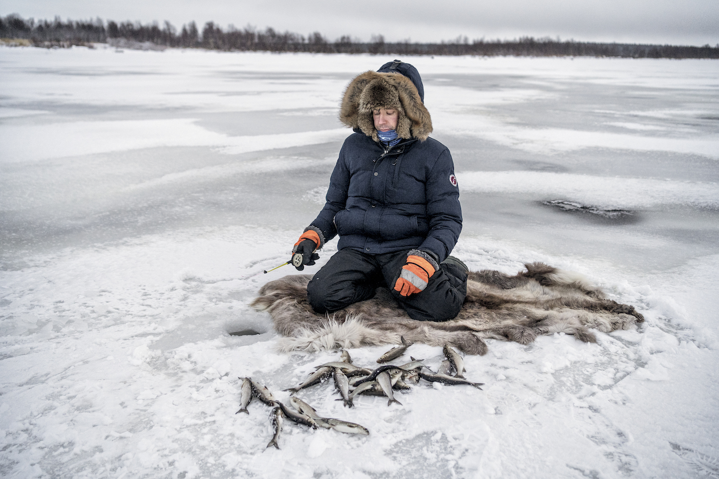 A fisherman surrounded by caught fish.