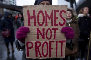 A housing protester holds a sign